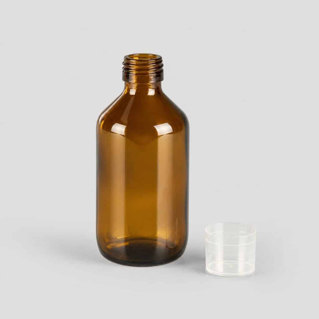 Flacon en verre teinté de solution buvable aux plantes et son bouchon-doseur