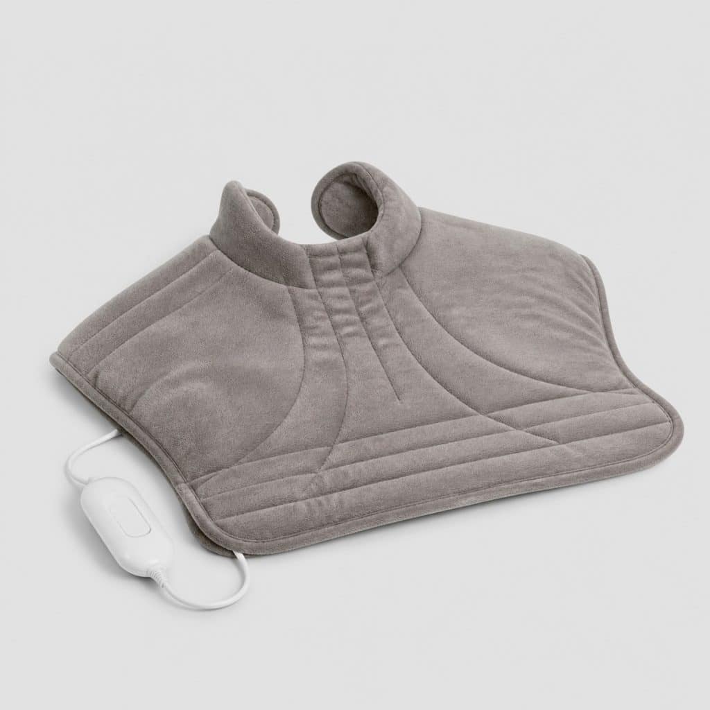 Coussin chauffant électrique en velours avec découpe pour la nuque, posé à plat