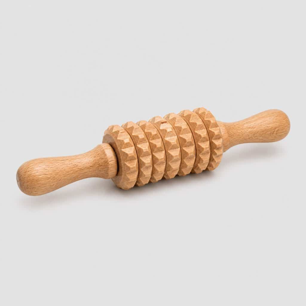 Rouleau de massage en bois massif à deux poignées sur fond neutre